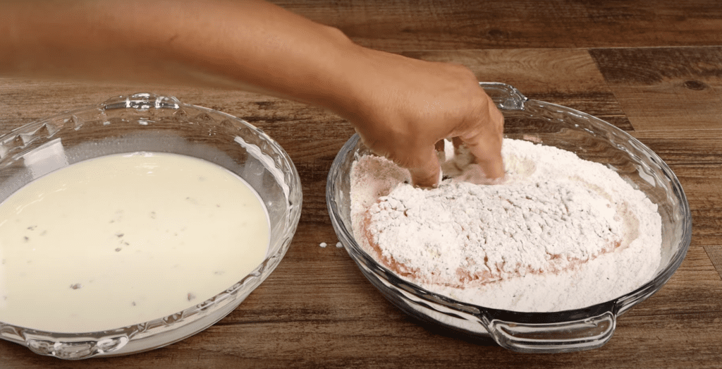 Dredging the steak in the seasoned flour