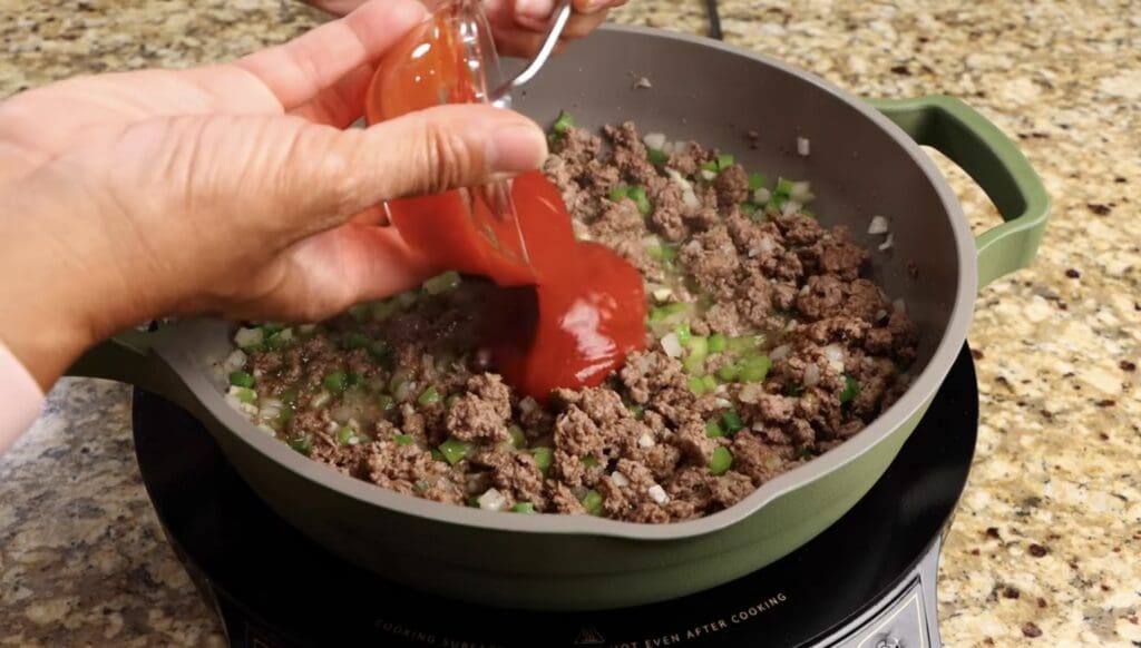 adding the ketchup, diced tomatoes and water to make sloppy joe recipe