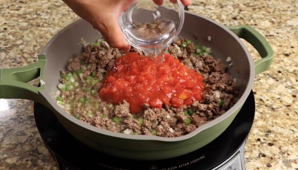 adding the diced tomatoes and water
